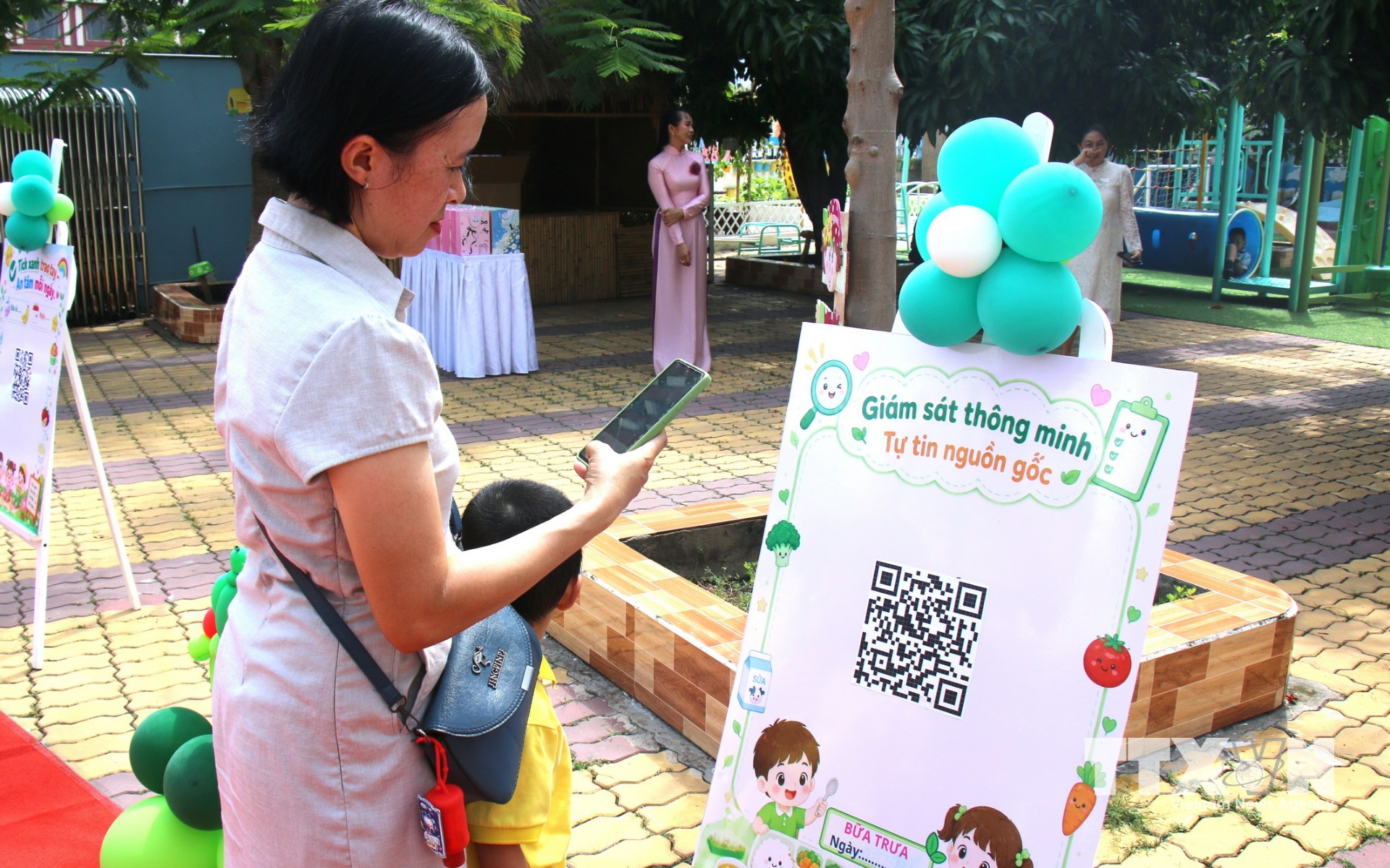 Phụ huynh trường Mầm non Phú Mỹ, Thành phố Hồ Chí Minh quét mã kiểm tra bữa ăn trưa theo mô hình "Tick xanh trách nhiệm". (Ảnh: Hương Giang/TTXVN)